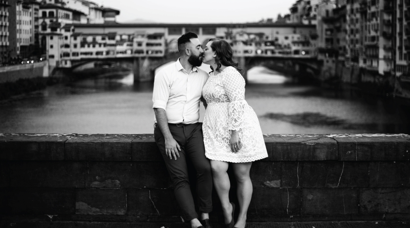 couple in florence italy taking their engagement portraits on the ponte vecchio